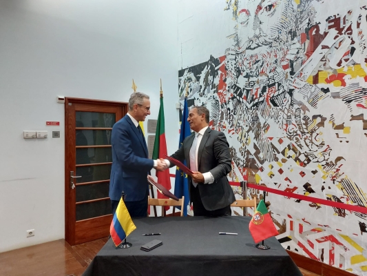 El embajador de Colombia, Alejandro Zaccour y el presidente del Instituto Camões, João Ribeiro de Almeida, se intercambian carpetas tras la firma del programa.